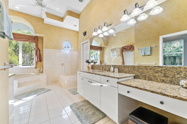 bathroom with tile patterned flooring, ceiling fan, a towering ceiling, vanity, and plus walk in shower