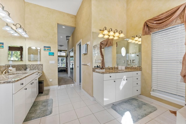 bathroom featuring vanity, a towering ceiling, and tile patterned flooring