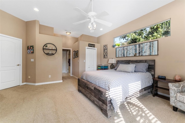 bedroom featuring light colored carpet, ceiling fan, and a closet