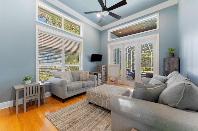 living room featuring a wealth of natural light, light hardwood / wood-style floors, crown molding, and ceiling fan