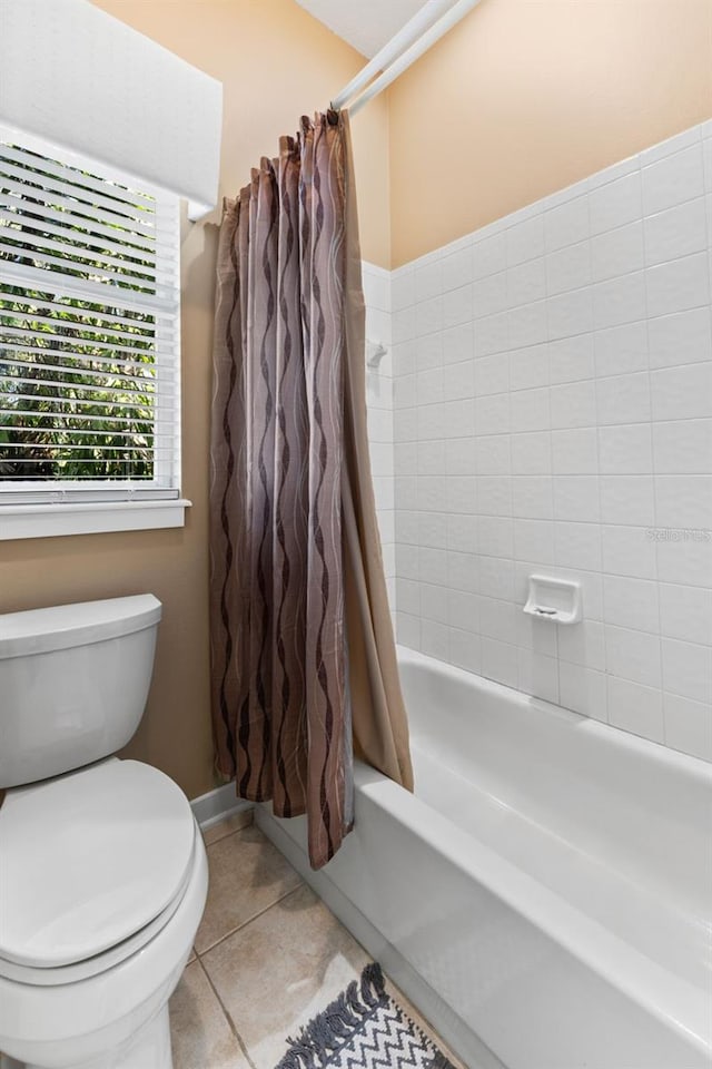 bathroom with toilet, tile patterned floors, and shower / tub combo with curtain