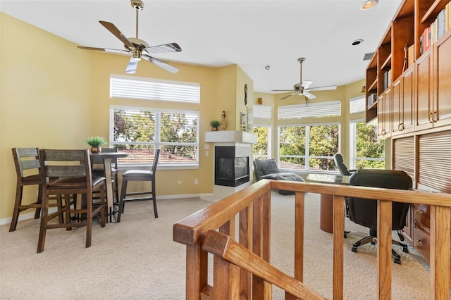 carpeted office featuring a multi sided fireplace