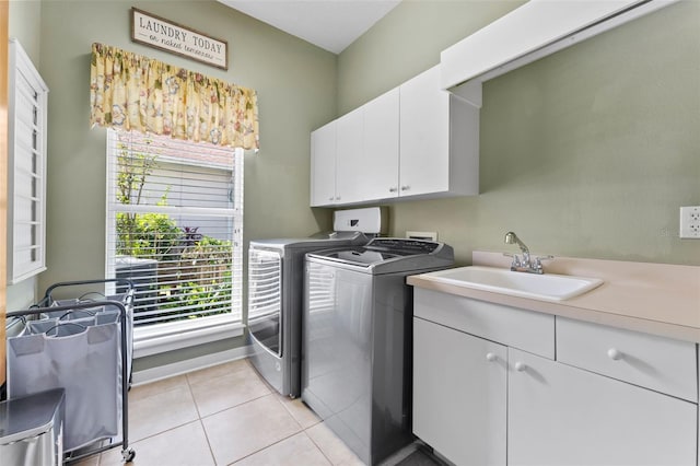 laundry area featuring separate washer and dryer, cabinets, sink, and light tile patterned floors