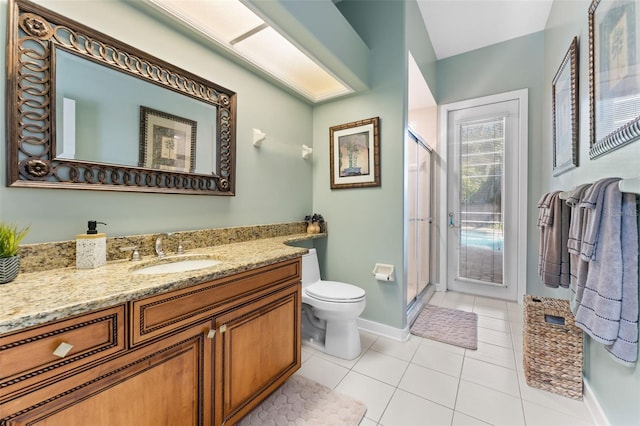 bathroom featuring vanity, a shower with shower door, tile patterned flooring, and toilet