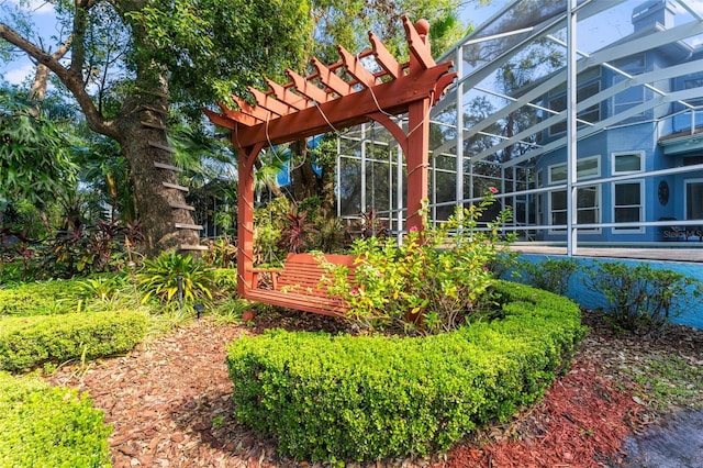 view of yard featuring glass enclosure and a pergola