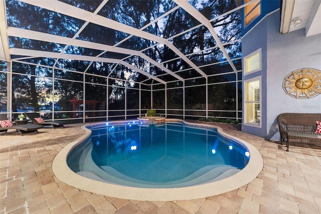 view of swimming pool featuring glass enclosure and a patio