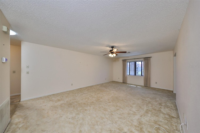 unfurnished room featuring a textured ceiling, light colored carpet, and ceiling fan