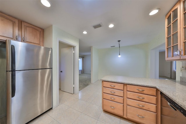 kitchen featuring light stone countertops, light tile patterned flooring, appliances with stainless steel finishes, and decorative light fixtures