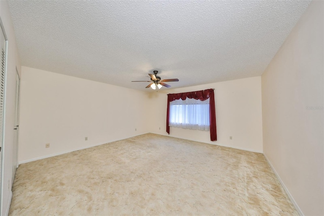 carpeted spare room featuring a textured ceiling and ceiling fan