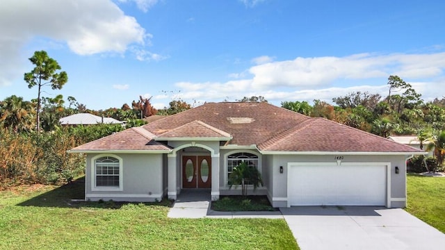 mediterranean / spanish-style house featuring a front lawn and a garage