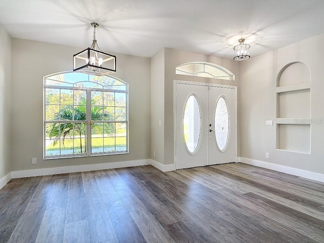 entrance foyer featuring french doors, hardwood / wood-style flooring, and a notable chandelier