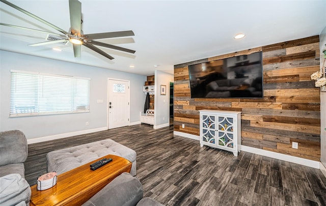 living room with wood walls, ceiling fan, and dark hardwood / wood-style flooring