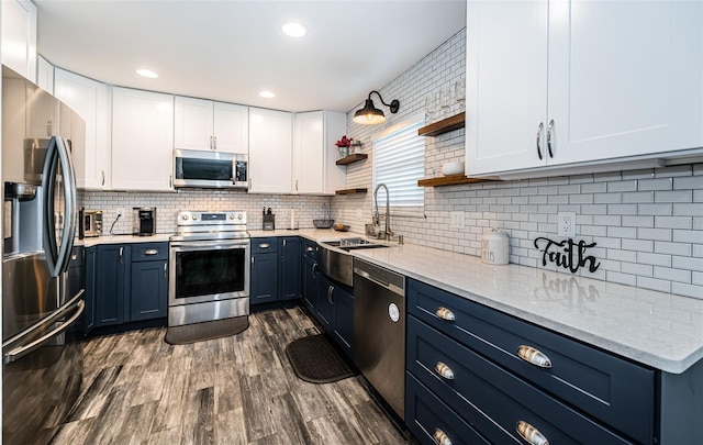 kitchen featuring sink, white cabinetry, stainless steel appliances, dark wood-type flooring, and decorative backsplash