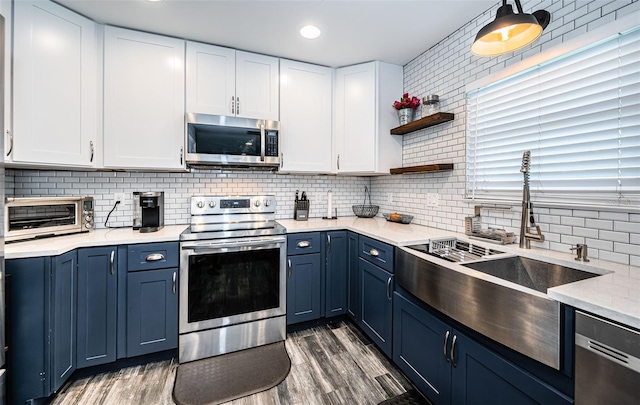 kitchen featuring blue cabinets, dark wood-type flooring, white cabinetry, and stainless steel appliances