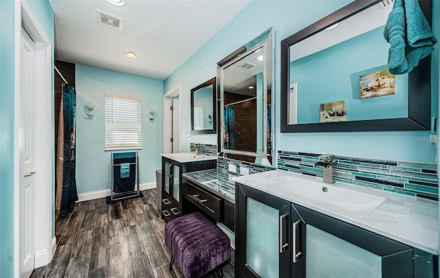 bathroom with vanity, wood-type flooring, walk in shower, and decorative backsplash