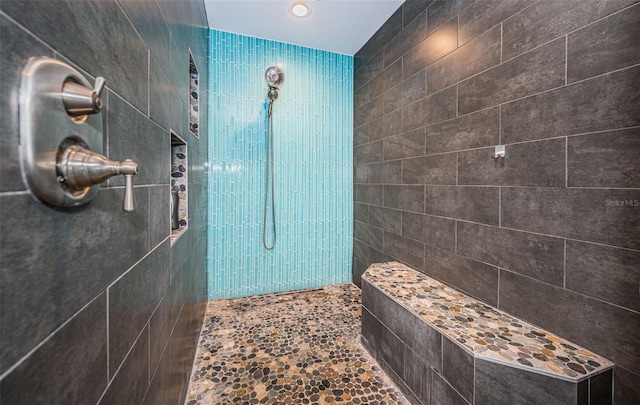 bathroom with tile walls and tiled shower