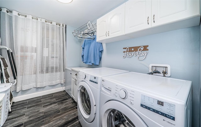 laundry area featuring cabinets, dark wood-type flooring, and washer and clothes dryer