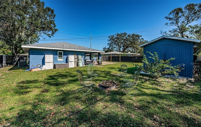 view of yard featuring a storage unit, a fire pit, and central AC unit