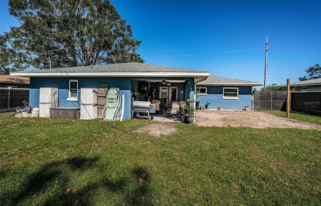 back of property with a yard and a patio area