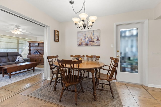 dining space with ceiling fan with notable chandelier and light tile patterned floors