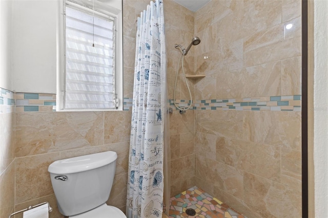 bathroom with tile walls, a shower with curtain, and toilet