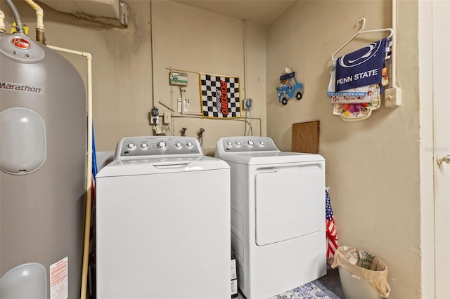 clothes washing area with washer and dryer and water heater