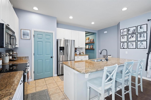 kitchen with a center island with sink, sink, white cabinetry, and stainless steel appliances