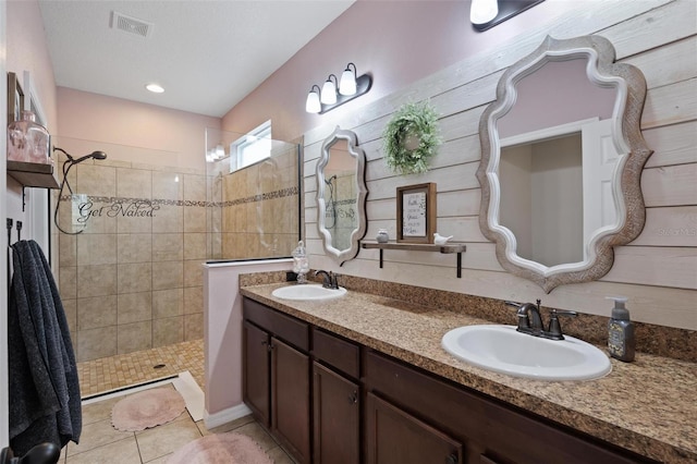 bathroom featuring vanity, tile patterned floors, and tiled shower