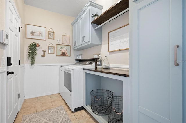 laundry room with light tile patterned flooring, cabinets, and separate washer and dryer