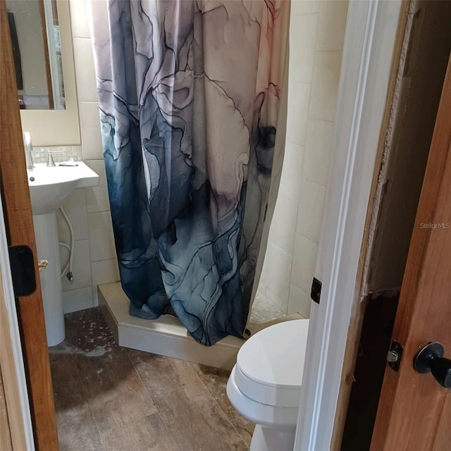 bathroom featuring toilet, tile walls, and a shower with shower curtain