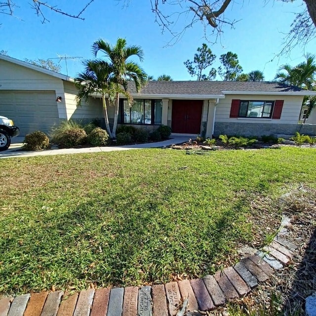 ranch-style home featuring a front lawn and a garage