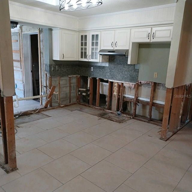 kitchen with crown molding, white cabinetry, backsplash, and light tile patterned floors