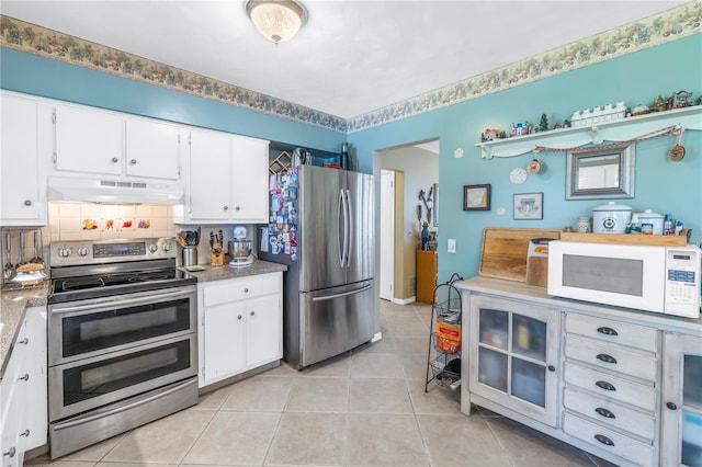 kitchen with light tile patterned flooring, white cabinetry, and stainless steel appliances