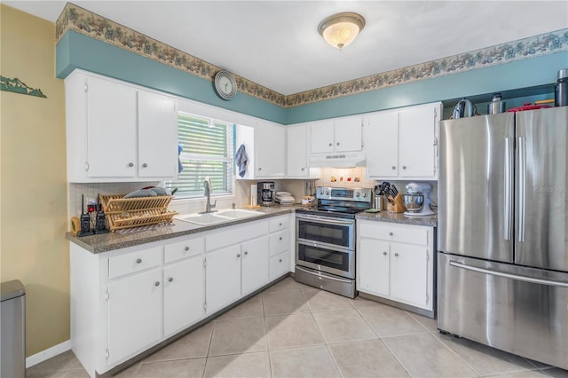 kitchen with white cabinets, stainless steel appliances, sink, backsplash, and light tile patterned floors