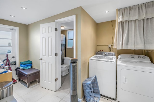 laundry area featuring light tile patterned floors and washer and clothes dryer