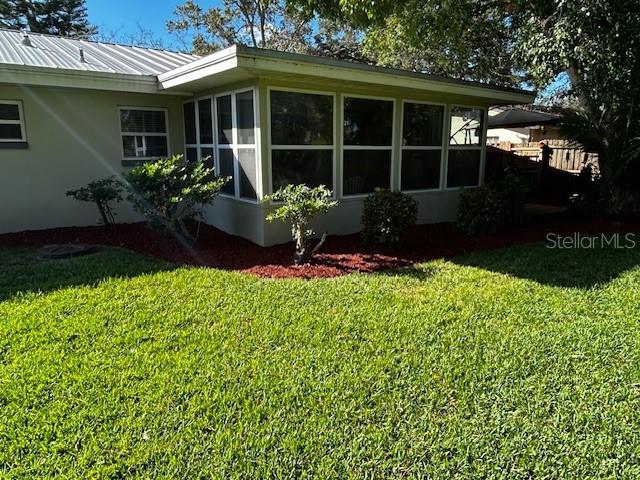 view of home's exterior featuring a yard and a sunroom