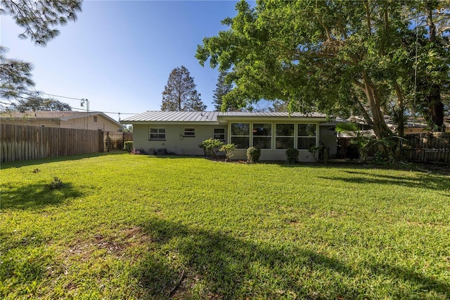 back of house with a sunroom and a yard