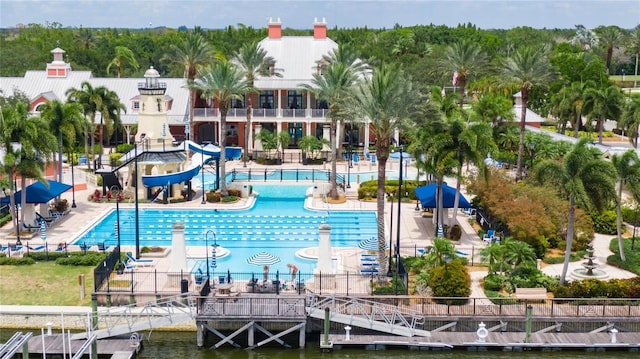 view of pool featuring a water view, a water slide, and a patio