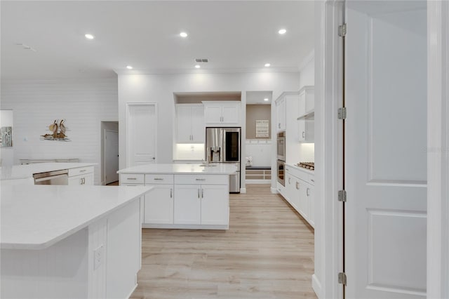 kitchen featuring a large island, white cabinetry, light hardwood / wood-style flooring, and stainless steel appliances