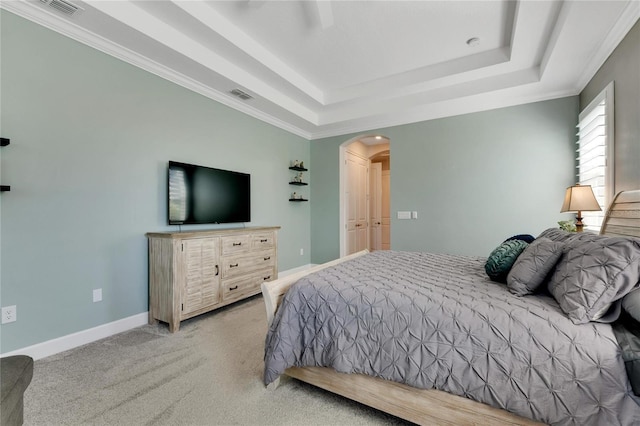 bedroom with ceiling fan, a raised ceiling, and light carpet