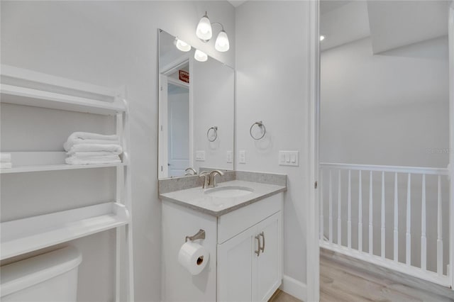 bathroom with vanity, hardwood / wood-style floors, and toilet