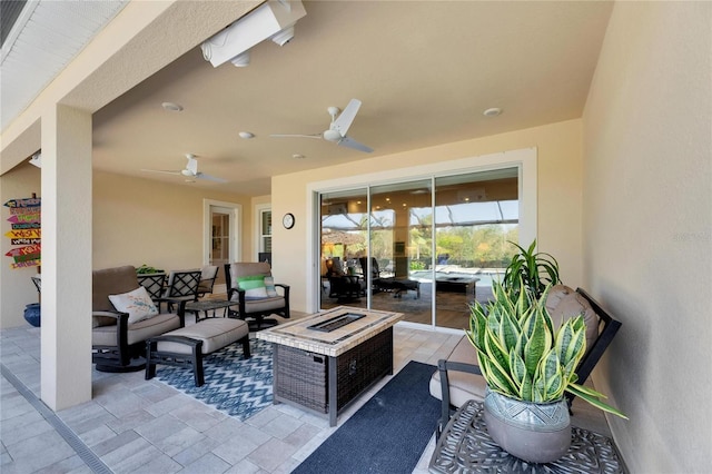 view of patio / terrace featuring ceiling fan and an outdoor living space with a fire pit