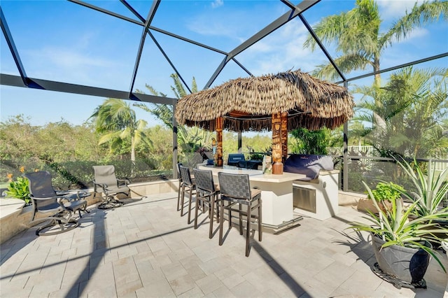 view of patio / terrace with area for grilling, a lanai, and exterior bar