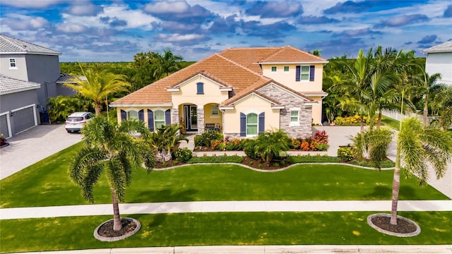 mediterranean / spanish-style house with a garage and a front yard