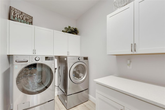 clothes washing area with washer and clothes dryer and cabinets