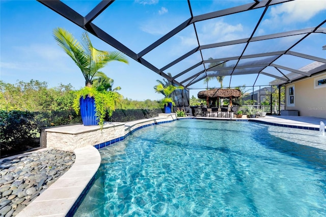 view of swimming pool featuring pool water feature, a lanai, and a patio