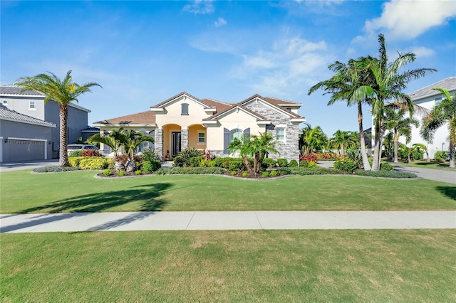 mediterranean / spanish home with a garage and a front yard