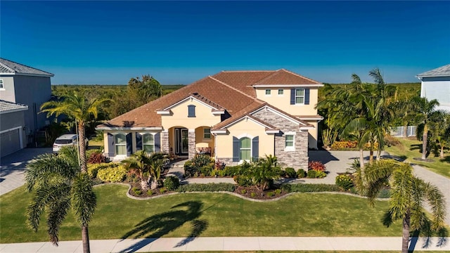 mediterranean / spanish house with a front lawn