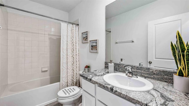 full bathroom featuring toilet, shower / bath combo with shower curtain, and vanity