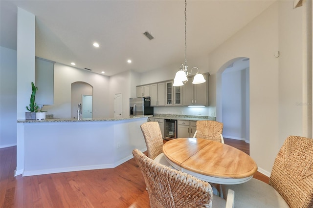 dining room with wine cooler, sink, dark wood-type flooring, and a chandelier